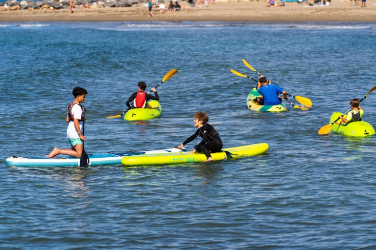 Niños practicando kayak y paddle surf en el mar en Cabopino
