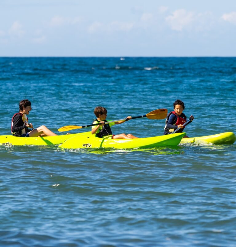 Niños remando en kayak en el mar