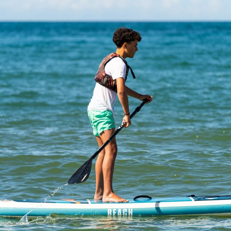 Chico haciendo paddle surf en el mar