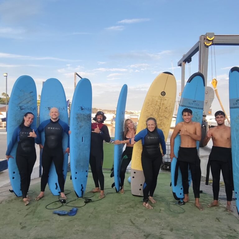 Grupo de adultos con tablas de surf en The Sail Experience