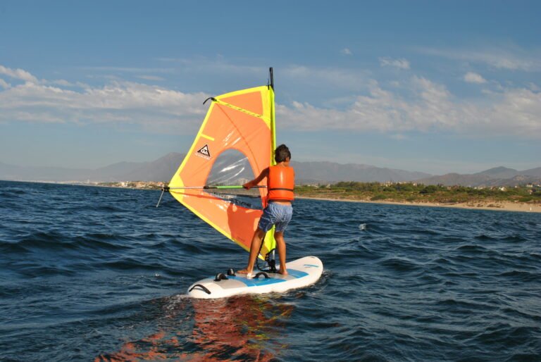 Niño haciendo windsurf en el mar en Marbella